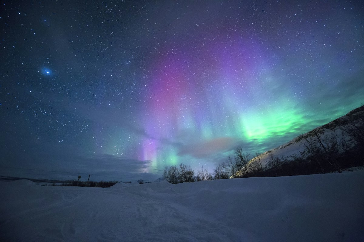 Viajes a Islandia Auroras Boreales y Círculo Dorado Cielo nocturno de Islandia iluminado por una espectacular aurora boreal verde sobre la nieve